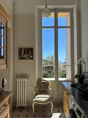 a kitchen with a chair and a large window at Parc Continental Apartment with sea view in Cannes