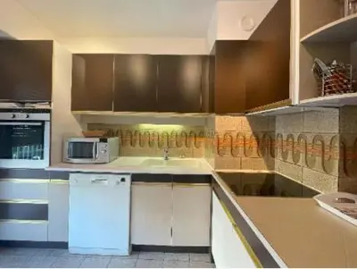 a kitchen with brown cabinets and a white refrigerator at Centre cannes Galia 210 m2 in Cannes