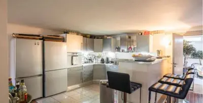 a kitchen with white cabinets and a refrigerator at Centre cannes Galia 210 m2 in Cannes