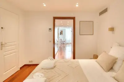 a white bedroom with a bed and a hallway at Cannes 50m palais & Croisette in Cannes