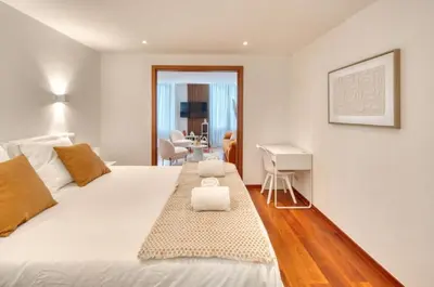 a bedroom with a large white bed and a desk at Cannes 50m palais & Croisette in Cannes