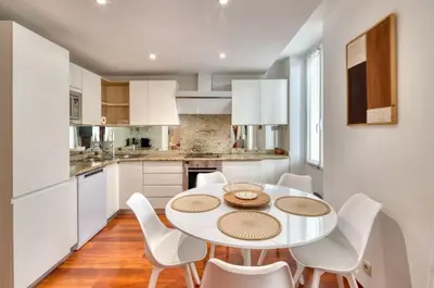 a kitchen with a white table and white chairs at Cannes 50m palais & Croisette in Cannes