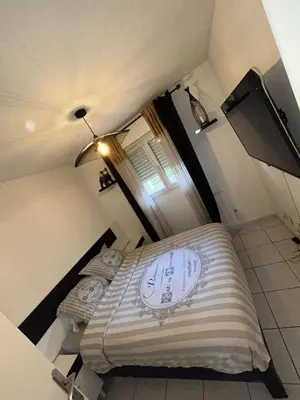 two beds in a small room with a window at 2P jardin Sud vue Lac avec piscine tennis parking privé in Le Cannet
