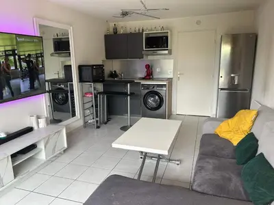 a living room with a couch and a table at 2P jardin Sud vue Lac avec piscine tennis parking privé in Le Cannet