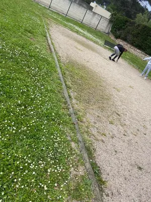 a man bending over in a field with a bench at 2P jardin Sud vue Lac avec piscine tennis parking privé in Le Cannet