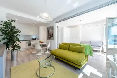 a living room with a green couch and a table at Bright Apartment in the Heart of Cannes in Cannes