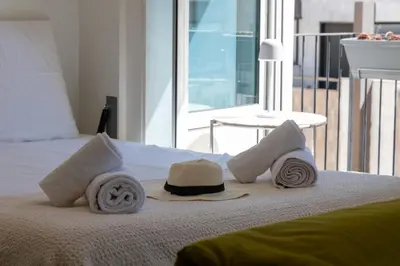 a bed with a hat and towels on it at Bright Apartment in the Heart of Cannes in Cannes