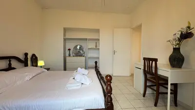 a bedroom with a bed and a desk and a chair at Reine des Mers in Cannes