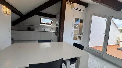 a white dining room with a white table and chairs at Reine des Mers in Cannes