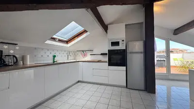 a kitchen with white cabinets and a skylight at Reine des Mers in Cannes