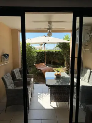 a patio with a table and an umbrella at Apartment with Garden, Pool, Sea View and Parking in Cannes