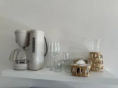 a counter with a coffee maker and glasses on it at Apartment with Garden, Pool, Sea View and Parking in Cannes