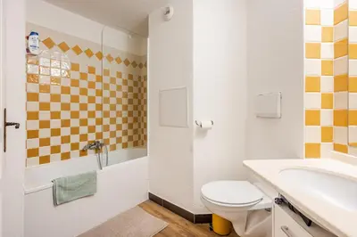 a white bathroom with a toilet and a sink at Apartment with Garden, Pool, Sea View and Parking in Cannes