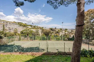 a tennis court in front of a building at Apartment with Garden, Pool, Sea View and Parking in Cannes