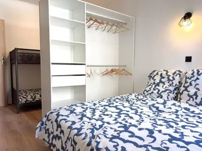 a bedroom with a bed and a closet at Suite Palmiers bleus Cannes in Cannes