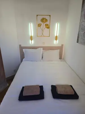 a bedroom with a white bed with two towels on it at RENOIR 1265 Villa Francia - F2 très belle vue mer in Cannes