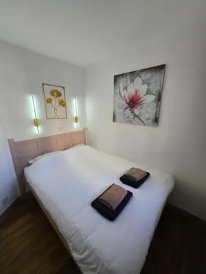 a bedroom with a white bed with two towels on it at RENOIR 1265 Villa Francia - F2 très belle vue mer in Cannes