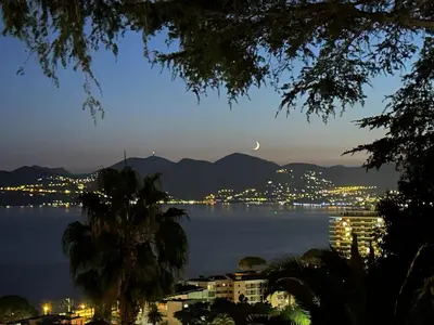 a view of a city and the water at night at RENOIR 1265 Villa Francia - F2 très belle vue mer in Cannes