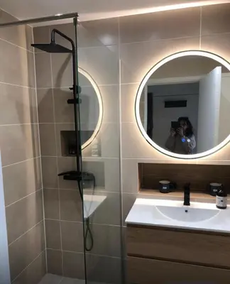 a woman taking a picture of a bathroom with a mirror at Studio terrasse Croisette in Cannes