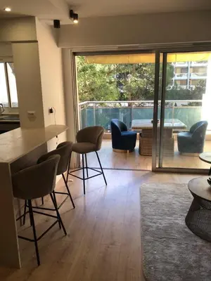 a room with chairs and a table and a large window at Studio terrasse Croisette in Cannes