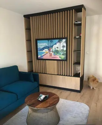 a living room with a blue couch and a tv at Studio terrasse Croisette in Cannes