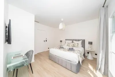 a white bedroom with a bed and a window at One of a kind 6 BR 6 bath villa sauna jacuzzi pool just 15 mns off town in Cannes