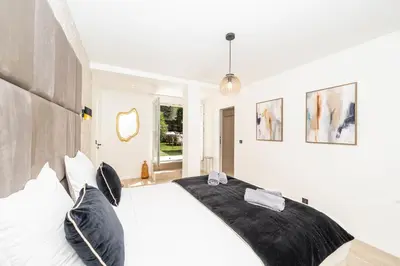 a bedroom with a large white bed with black pillows at One of a kind 6 BR 6 bath villa sauna jacuzzi pool just 15 mns off town in Cannes