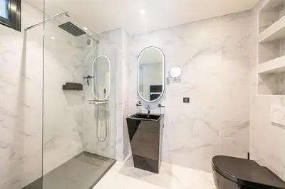 a bathroom with a shower and a sink and a mirror at One of a kind 6 BR 6 bath villa sauna jacuzzi pool just 15 mns off town in Cannes
