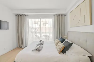 a bedroom with a white bed with a large window at REF 1493 - Cannes -City Center Banane District in Cannes