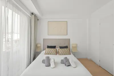 a white bedroom with a white bed and a window at REF 1493 - Cannes -City Center Banane District in Cannes