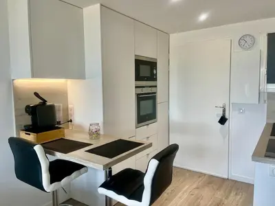 a kitchen with a table with two chairs and a microwave at Holidays in Cannes