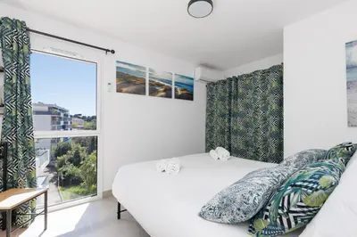a bedroom with a bed and a large window at Immogroom - t2 new - bright - fully equipped in Cannes
