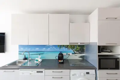 a kitchen with white cabinets and a sink at Immogroom - t2 new - bright - fully equipped in Cannes