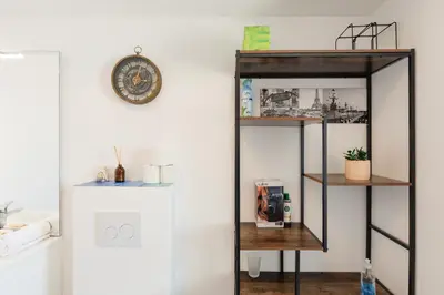a shelf in a room with a clock on a wall at Immogroom - t2 new - bright - fully equipped in Cannes