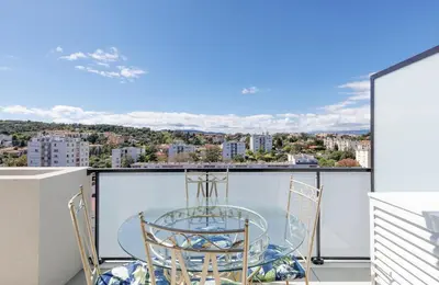 a glass table and chairs on a balcony with a view at Immogroom - t2 new - bright - fully equipped in Cannes
