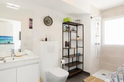 a white bathroom with a toilet and a sink at Immogroom - t2 new - bright - fully equipped in Cannes