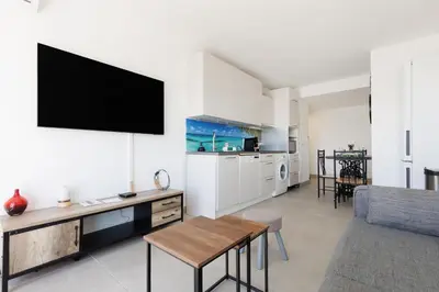 a living room with a tv on a white wall at Immogroom - t2 new - bright - fully equipped in Cannes