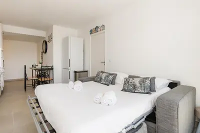 a bedroom with a large white bed with pillows at Immogroom - t2 new - bright - fully equipped in Cannes