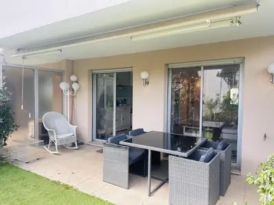 a patio with a table and chairs in a house at Light modern Studio with Garden terrace shared pool - 2294 in Cannes