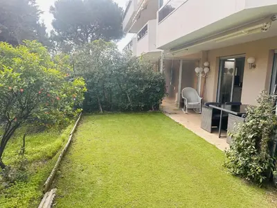a yard with a lawn in front of a house at Light modern Studio with Garden terrace shared pool - 2294 in Cannes