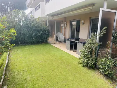 a yard with a desk and a chair next to a house at Light modern Studio with Garden terrace shared pool - 2294 in Cannes