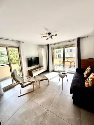 a living room with a couch and chairs and windows at Appartement cosy avec terrasse, proche plages & Palais in Cannes