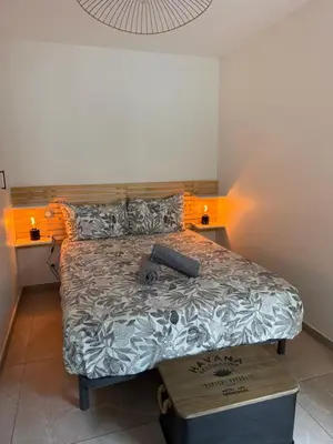 a bedroom with a large bed with a wooden headboard at Appartement cosy avec terrasse, proche plages & Palais in Cannes