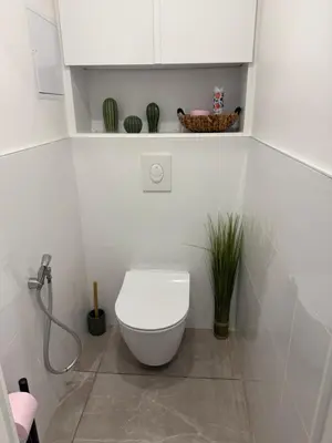 a white bathroom with a toilet and a shower at Appartement cosy avec terrasse, proche plages & Palais in Cannes