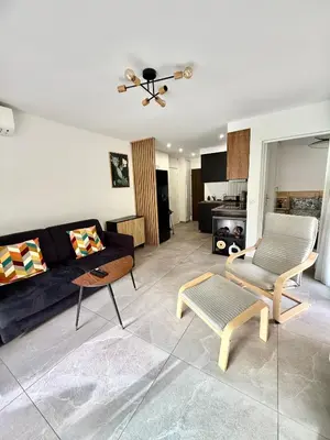 a living room with a couch and a table at Appartement cosy avec terrasse, proche plages & Palais in Cannes