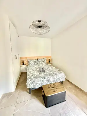 a bedroom with a bed and a chandelier at Appartement cosy avec terrasse, proche plages & Palais in Cannes