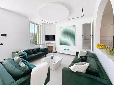 a living room with two green couches and a fireplace at Modern 5-bedroom villa with swimming pool in Cannes in Cannes