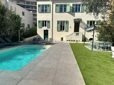 a house with a swimming pool in front of a building at Modern 5-bedroom villa with swimming pool in Cannes in Cannes