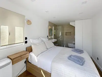 a bedroom with a white bed and a bathroom at Modern 5-bedroom villa with swimming pool in Cannes in Cannes