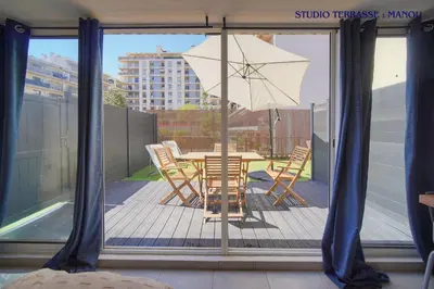a table and chairs with an umbrella on a balcony at VCA House -5 appartements - 15Min Mer- Wifi-Clim in Cannes